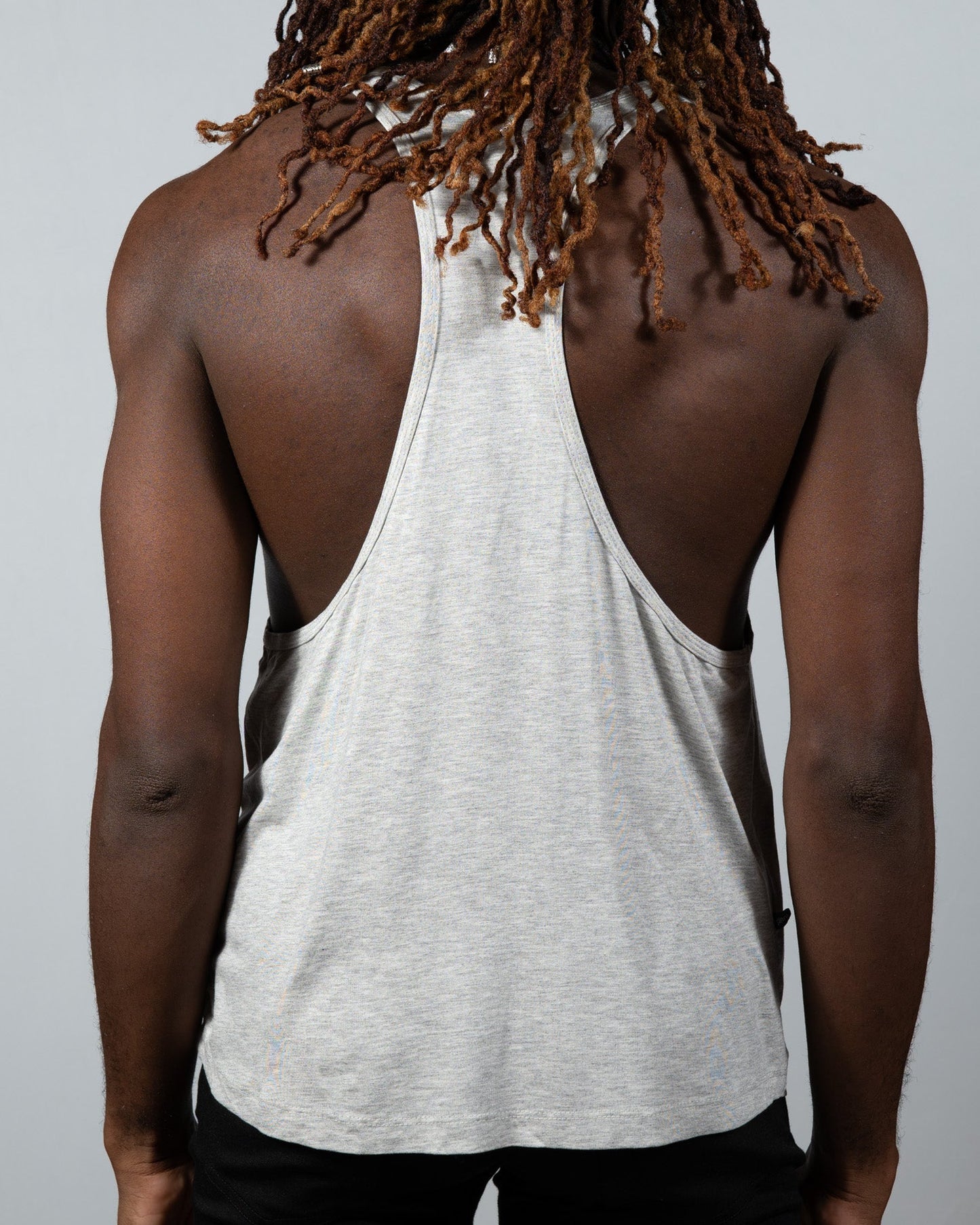 A heather gray tulio racerback tank with relaxed fit and subtle side seam detailing shown from the back side
