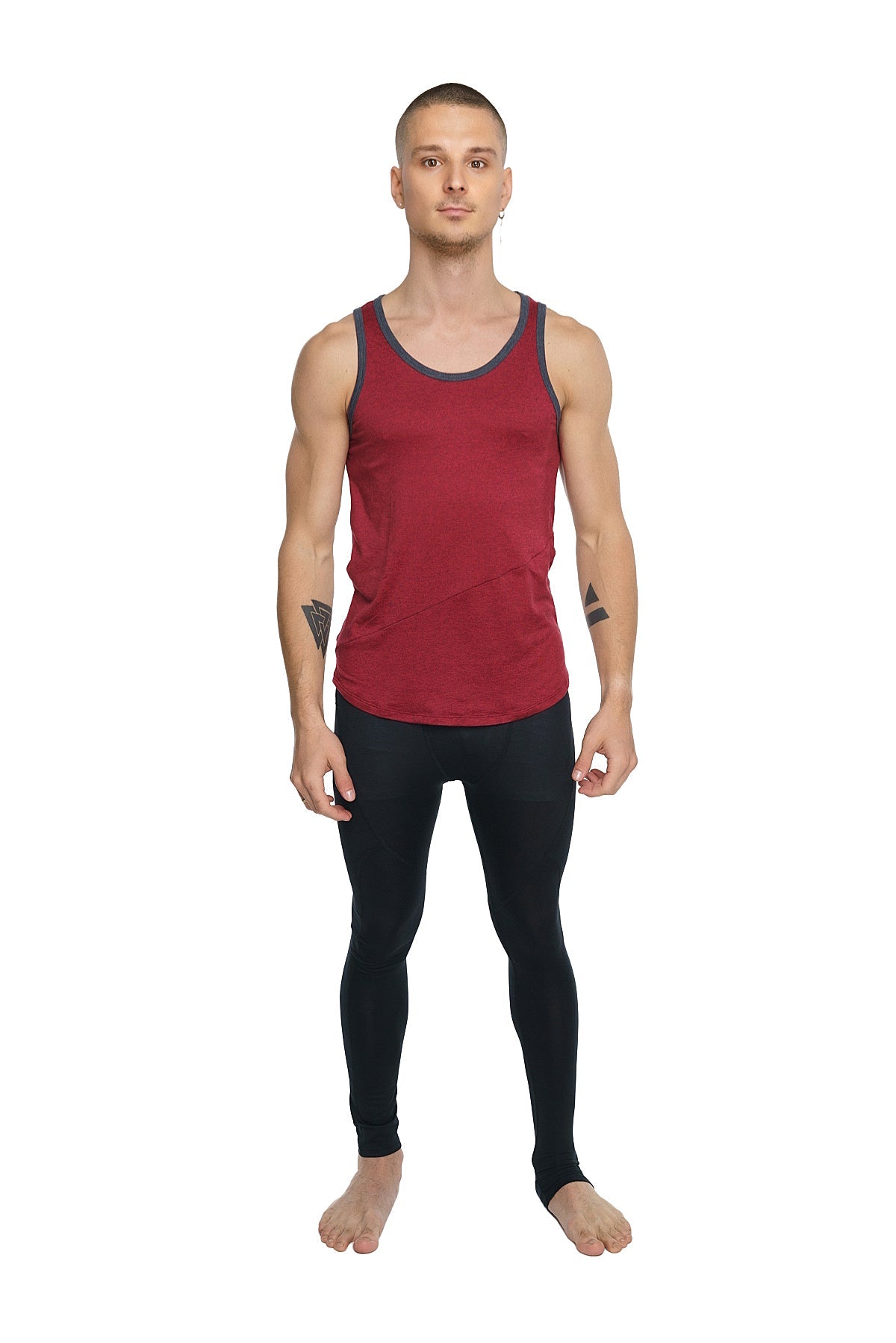 A man wearing a brick red tank top with dark gray trim and black leggings showcasing the perfect tank product