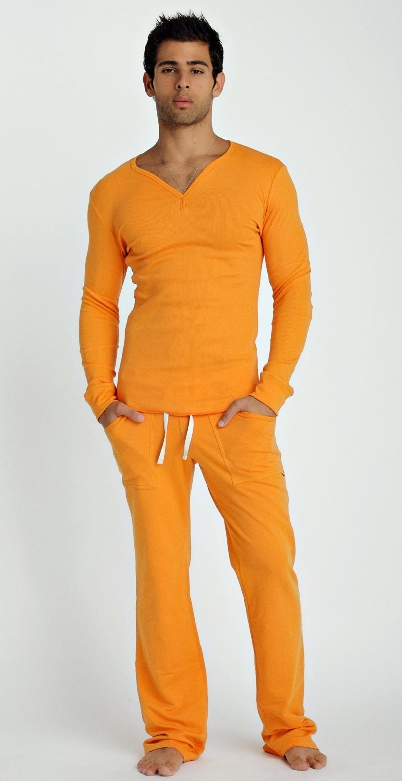A man wearing a sun orange thermal v-neck long sleeve top and matching pants with white drawstrings