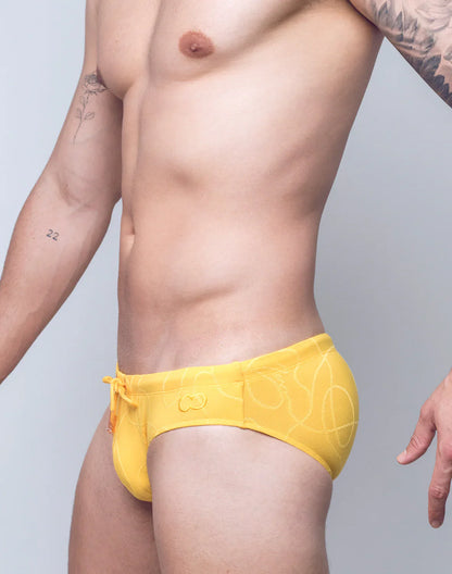 Bright yellow v10 ripple textured swim brief with subtle abstract pattern and orange drawstring for swimming