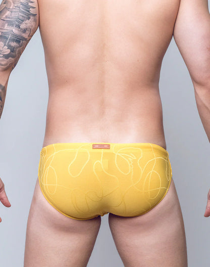 Yellow V10 ripple textured swim brief with subtle white abstract line pattern designed for swimwear use