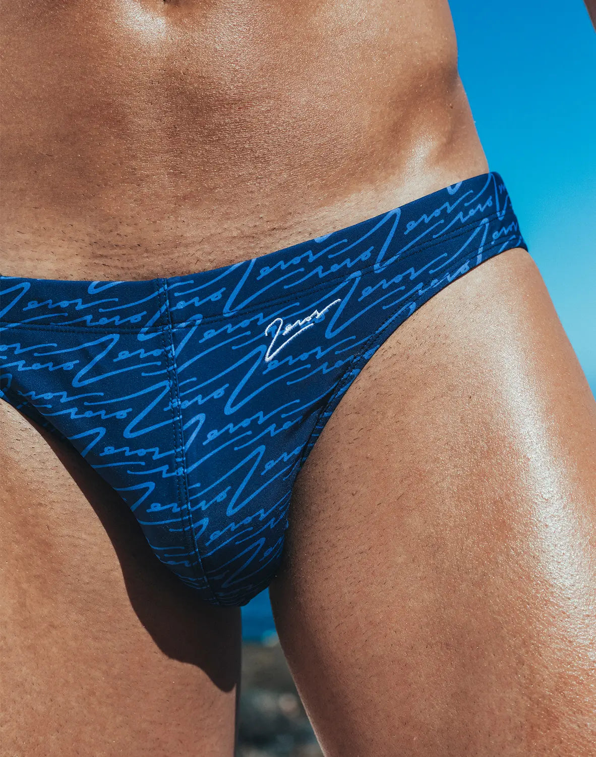 Dark blue v20 signature print swim brief with light blue cursive pattern and white zeros logo on waistband