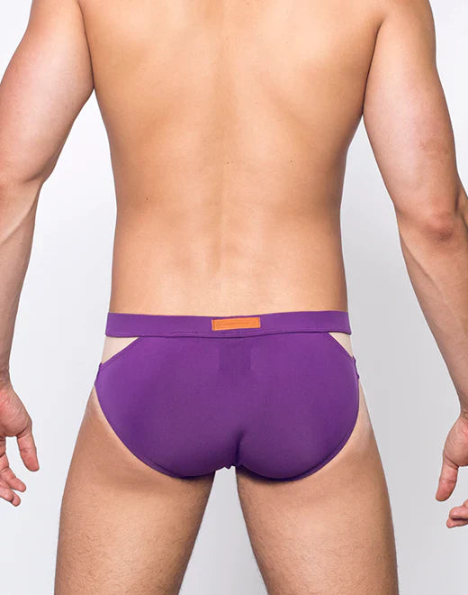 Purple VB21 BLK LABEL swim brief with contrasting orange rectangular tag on waistband designed for athletic use