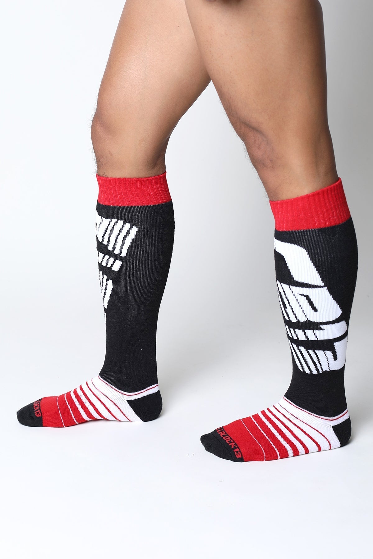 Velocity 2.0 knee high athletic socks in black and red with bold white graphic design for sports use