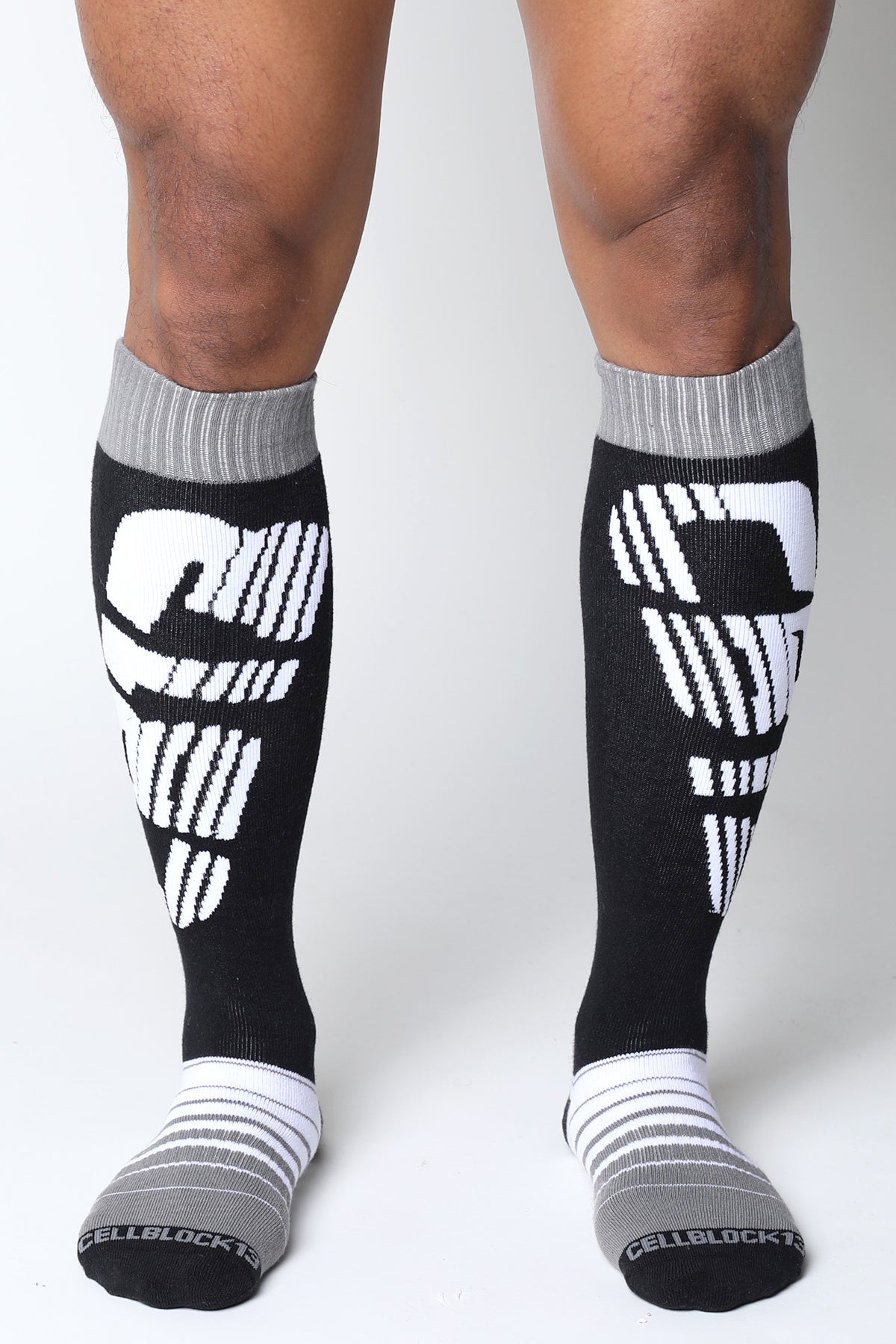 Black and white velocity 2.0 knee high compression socks with bold skull design on calf in back view