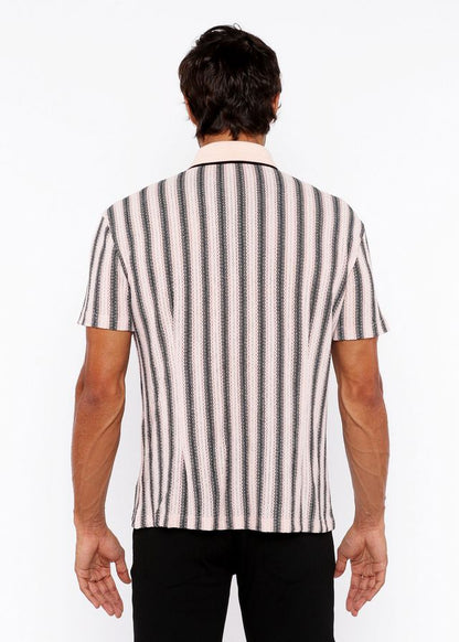 A man wearing a vertical stripe open stretch knit shirt with rib collar in black and off-white textured fabric