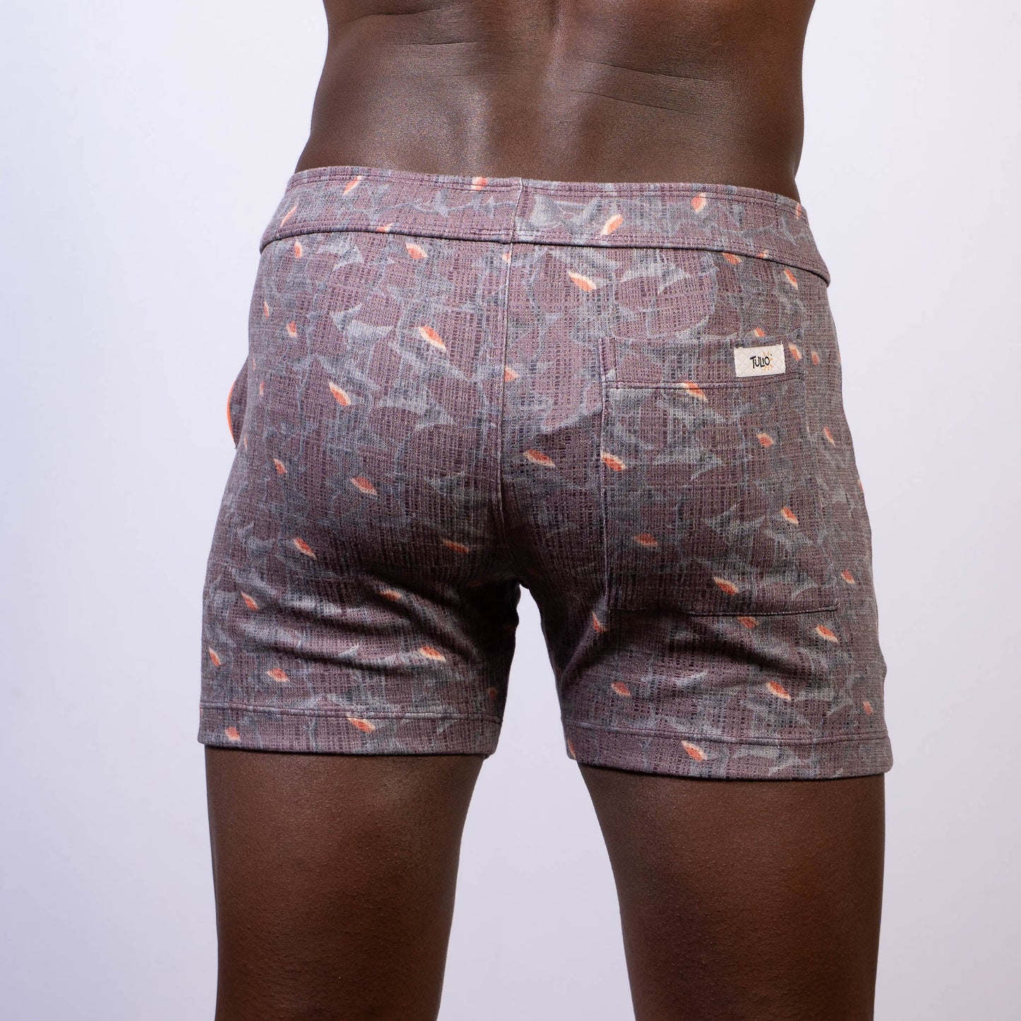Back side of vintage stripes linen texture gray shorts with subtle weave and orange fish motifs with branded label