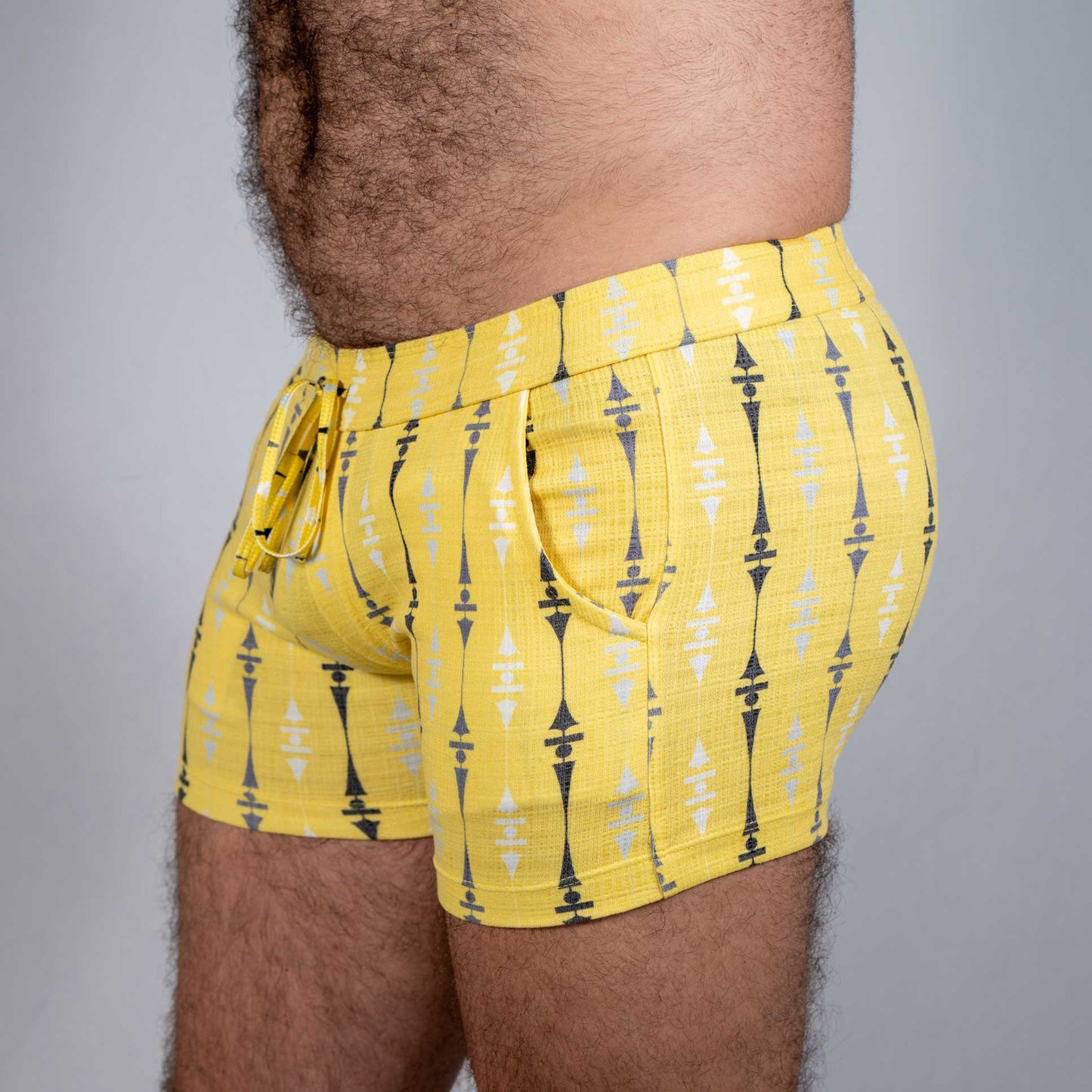 Bright yellow wallpaper print linen texture shorts with bold black and white geometric pattern and elastic waistband