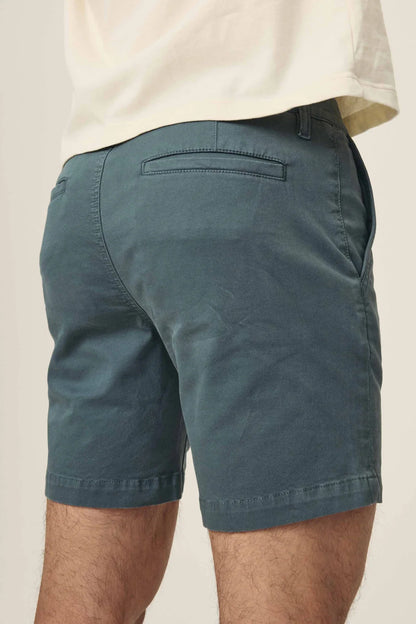 Rear view of dark teal chino shorts with welt pockets and a white t-shirt.