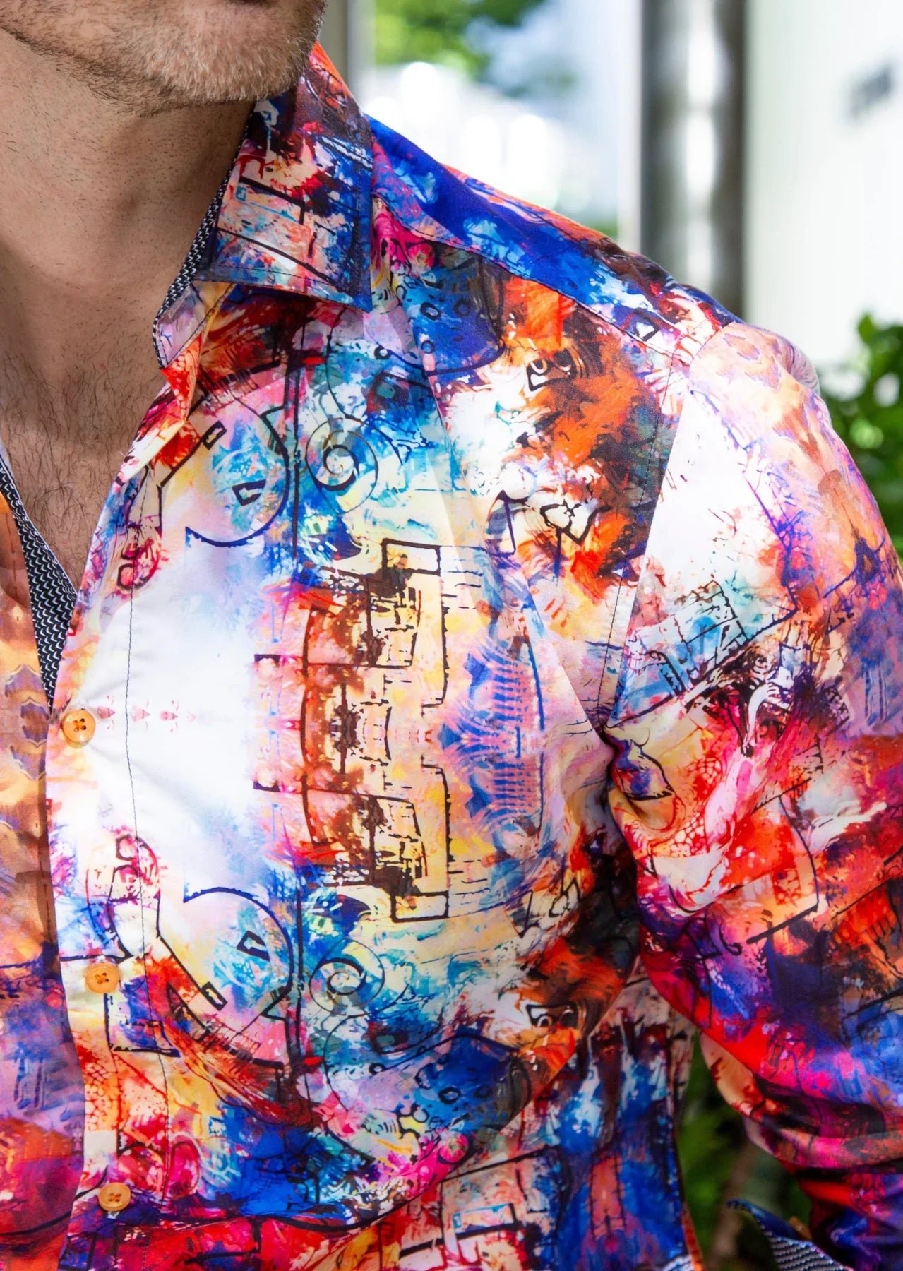 Vibrant long-sleeved button-down shirt with bold abstract architectural print in blues reds oranges and purples on white base