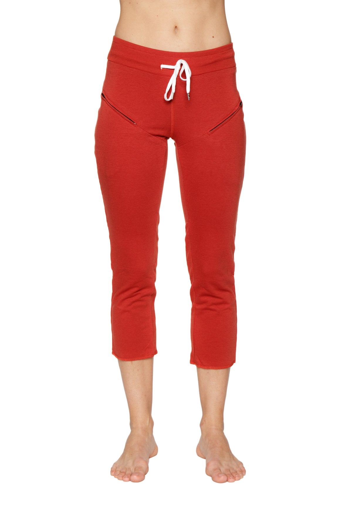 Women’s cinnabar red cropped jogger pants with white drawstring waistband and diagonal zipper pockets for yoga