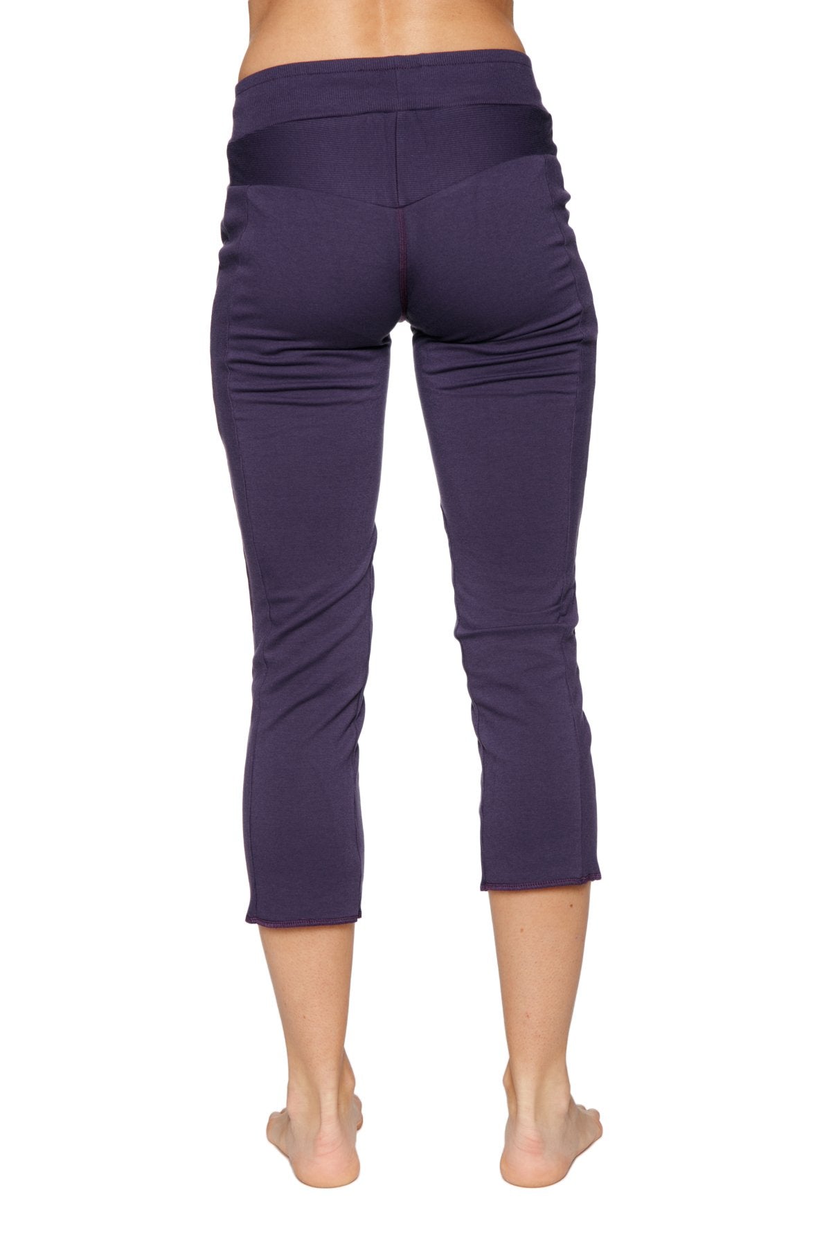 Women’s eggplant capri yoga pants with high-waisted elastic band and smooth stretchy fabric featuring zipper pockets