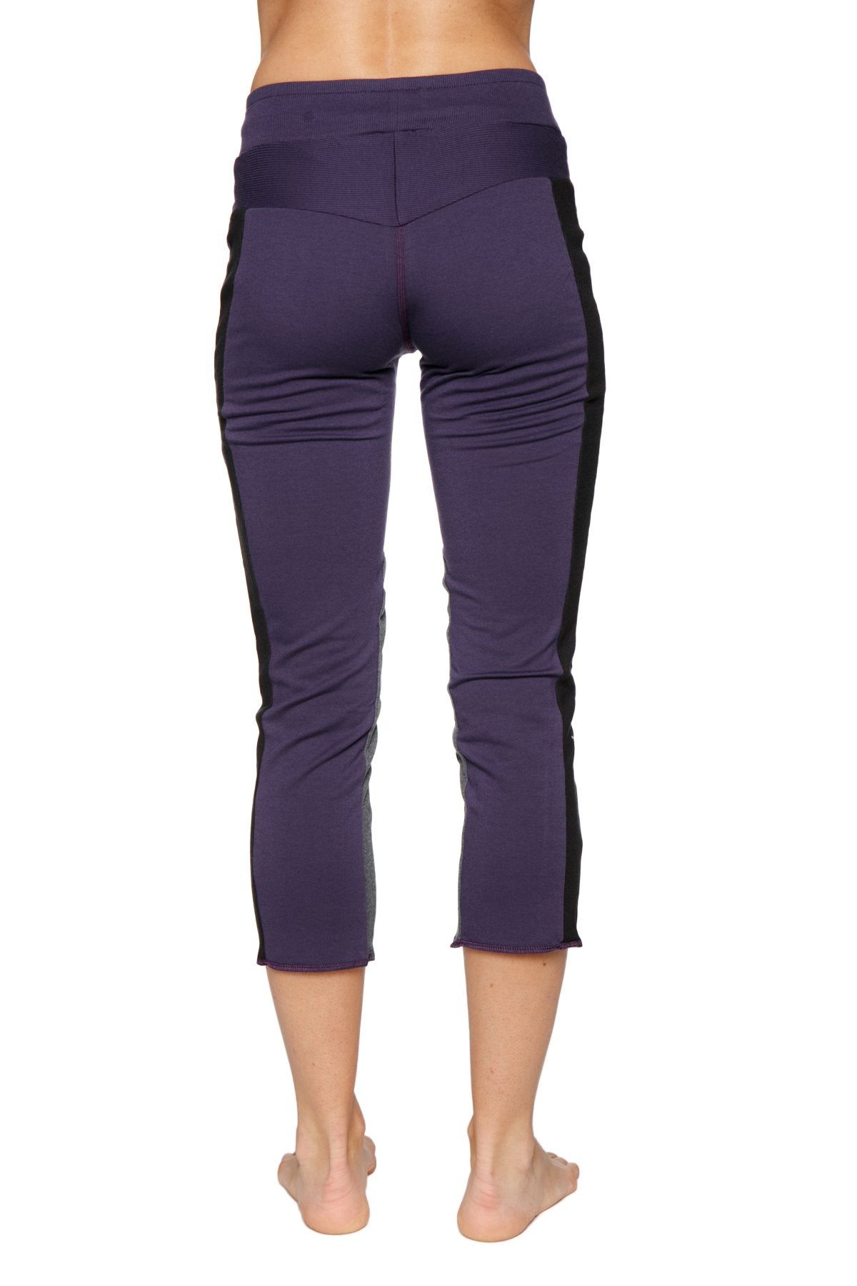 Women’s 4/5 length zipper pocket capri yoga pant in eggplant with black side panels and high-waisted elastic waistband