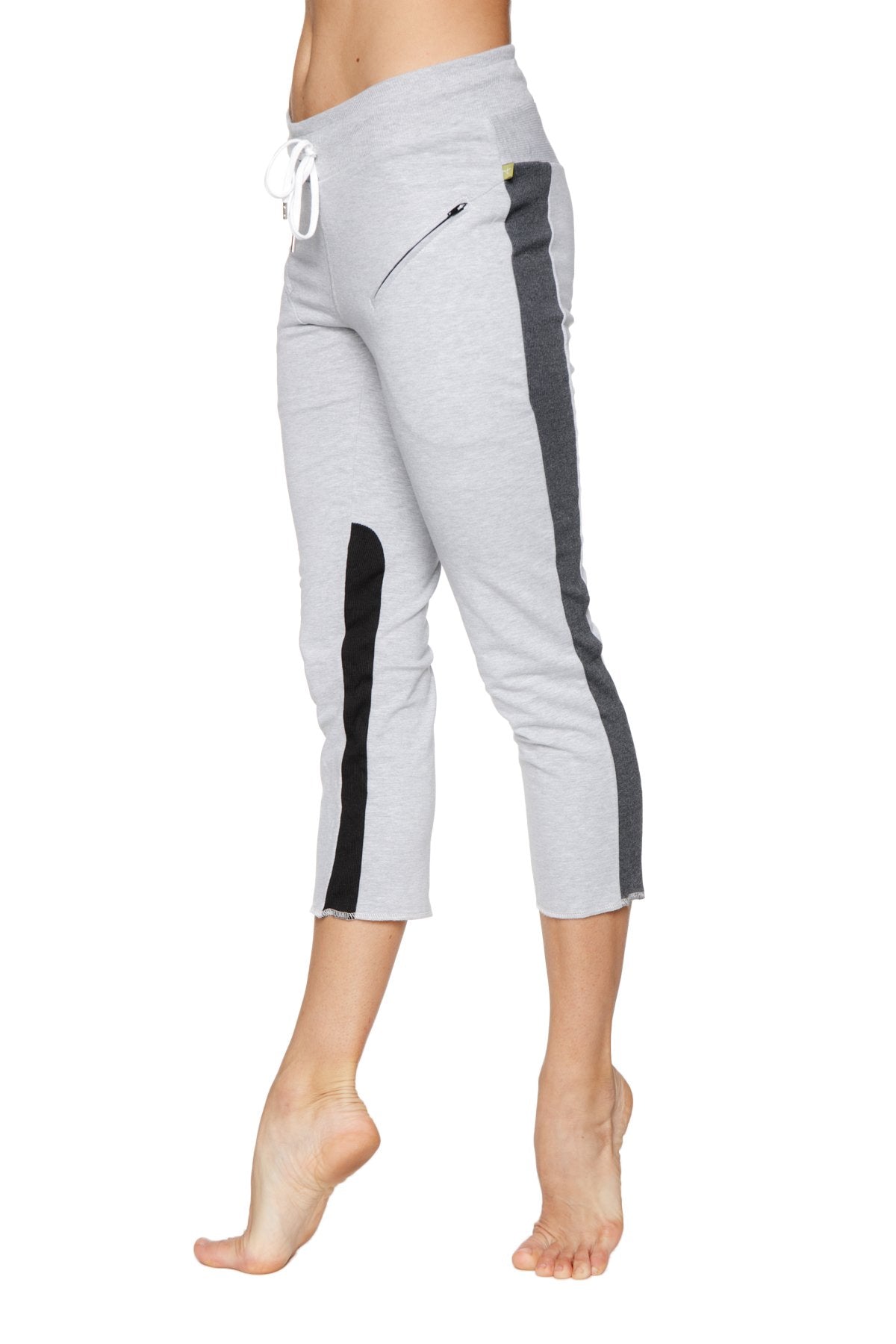 Women’s gray capri yoga pants with black and charcoal side stripes, white drawstring waistband, and zippered pockets