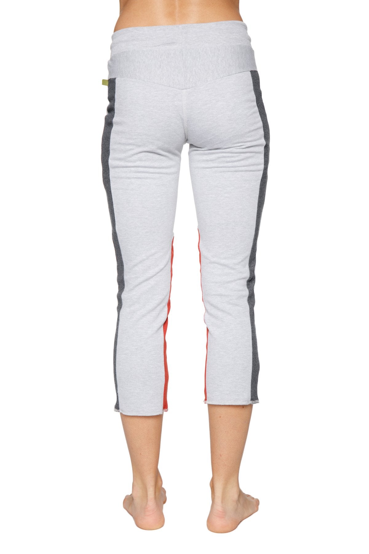 Women’s grey capri yoga pants with charcoal and red side stripes and zipper pockets for active wear