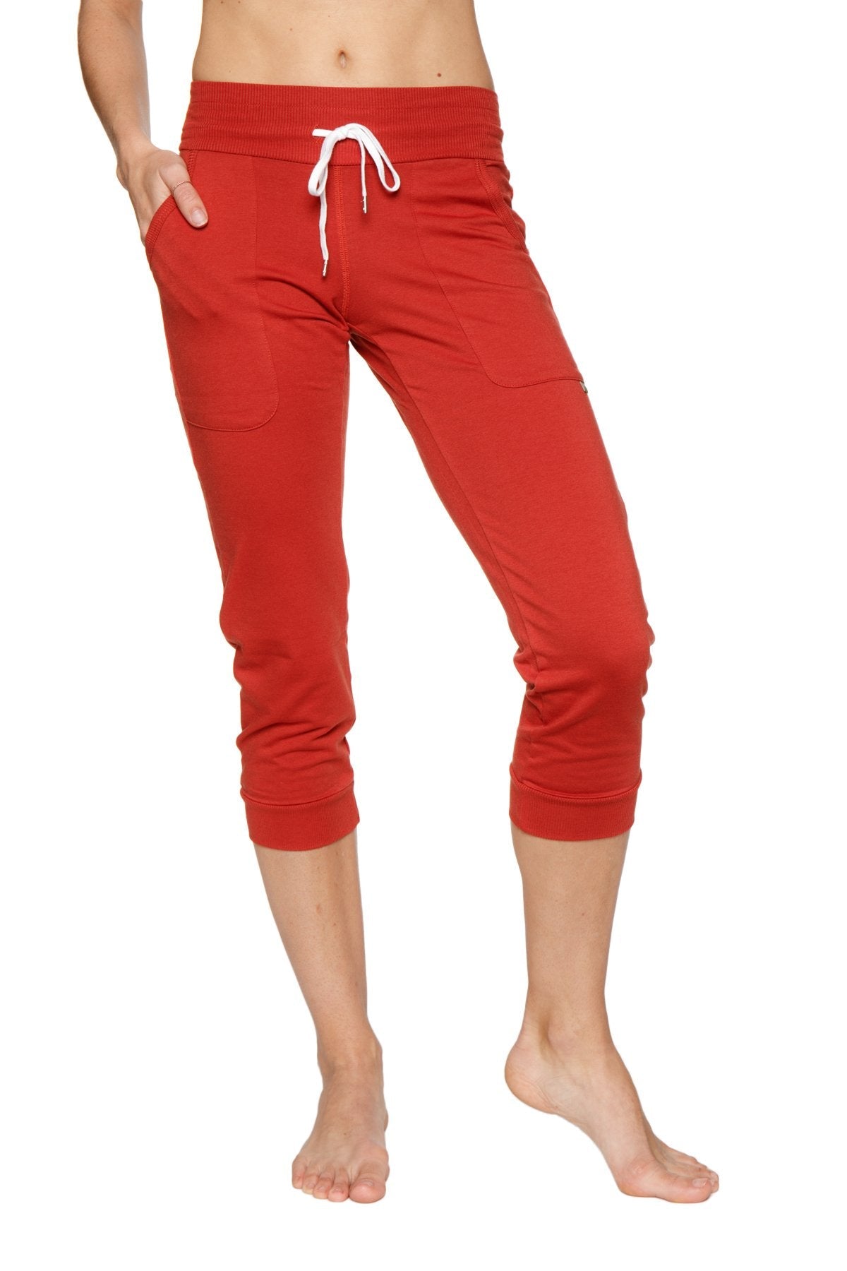 Women’s red cuffed capri-length jogger yoga pants with white drawstring waistband and side pockets in cinnabar color