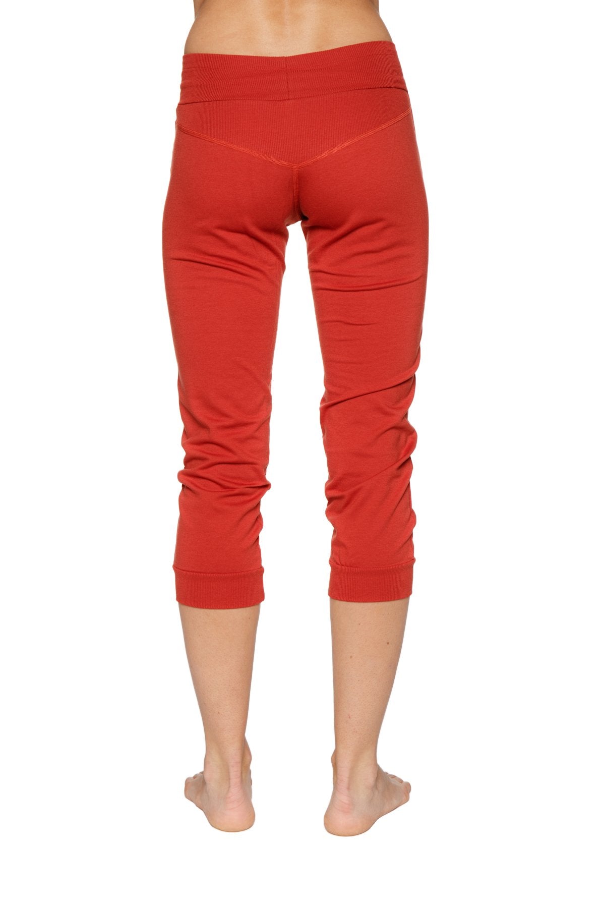 Women’s cinnabar red cuffed jogger yoga pants with stretchy form-fitting fabric and subtle ruching at lower legs