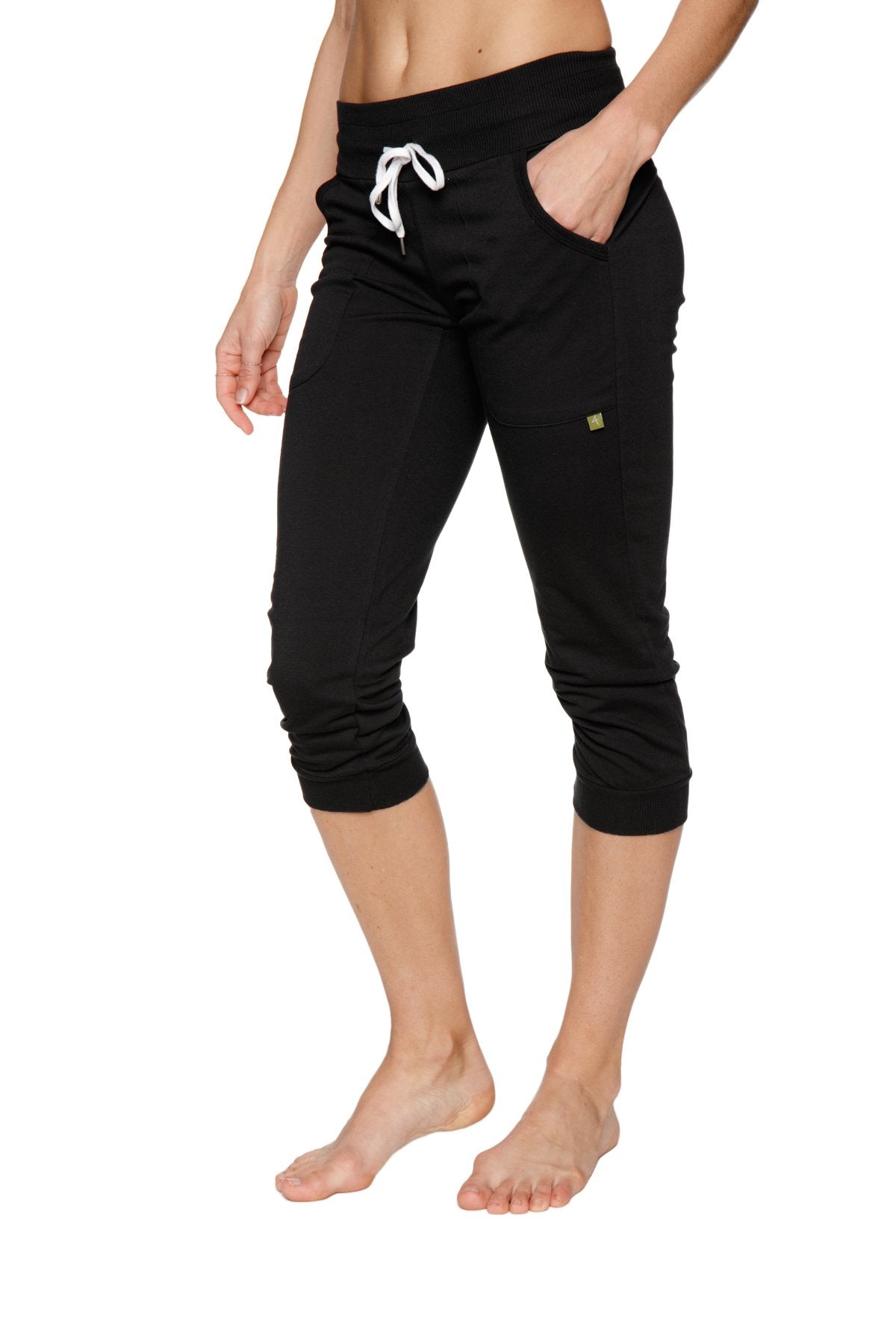 Women’s cuffed jogger yoga pant in solid black with white drawstring waistband and side pockets in capri length