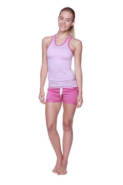 A woman wearing a light pink and white striped halter tank top with matching bright pink women’s performance yoga shorts