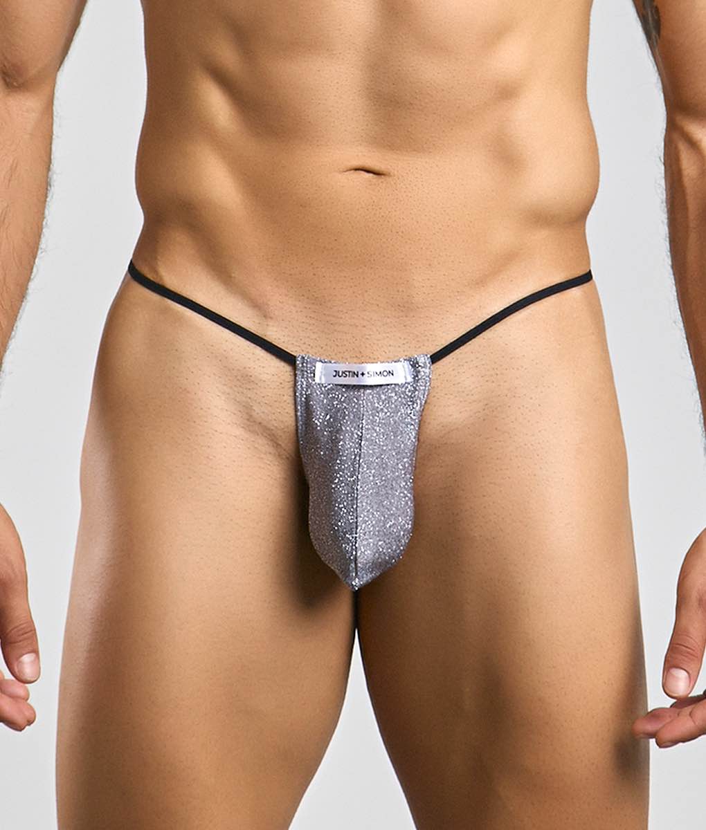 Silver glittery classic g-string bulge thong with black elastic waistband and white justin simon label visible