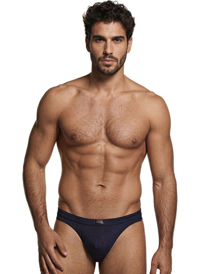 Xtremen navy blue bikini brief with a subtle geometric pattern and matte fabric finish worn by a fit male model.