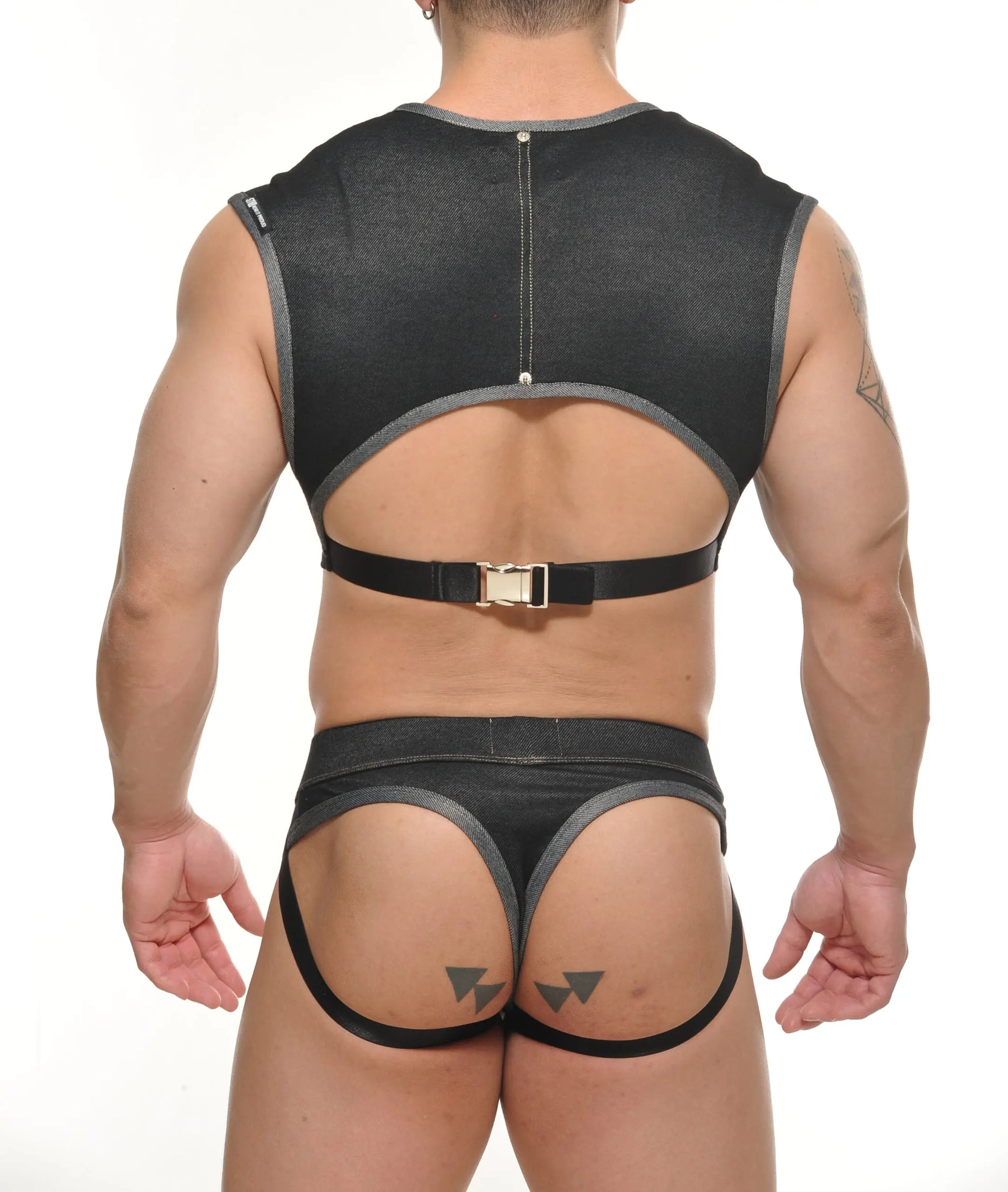 Black denim-like fabric harness with gray trim and gold-toned buckle featured in yannick muscle top