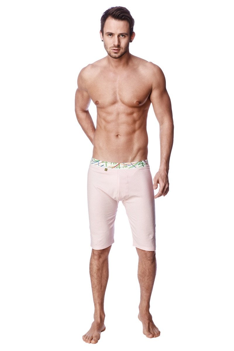 Light pink yoga compression shorts with form fitting design and decorative green and white patterned waistband