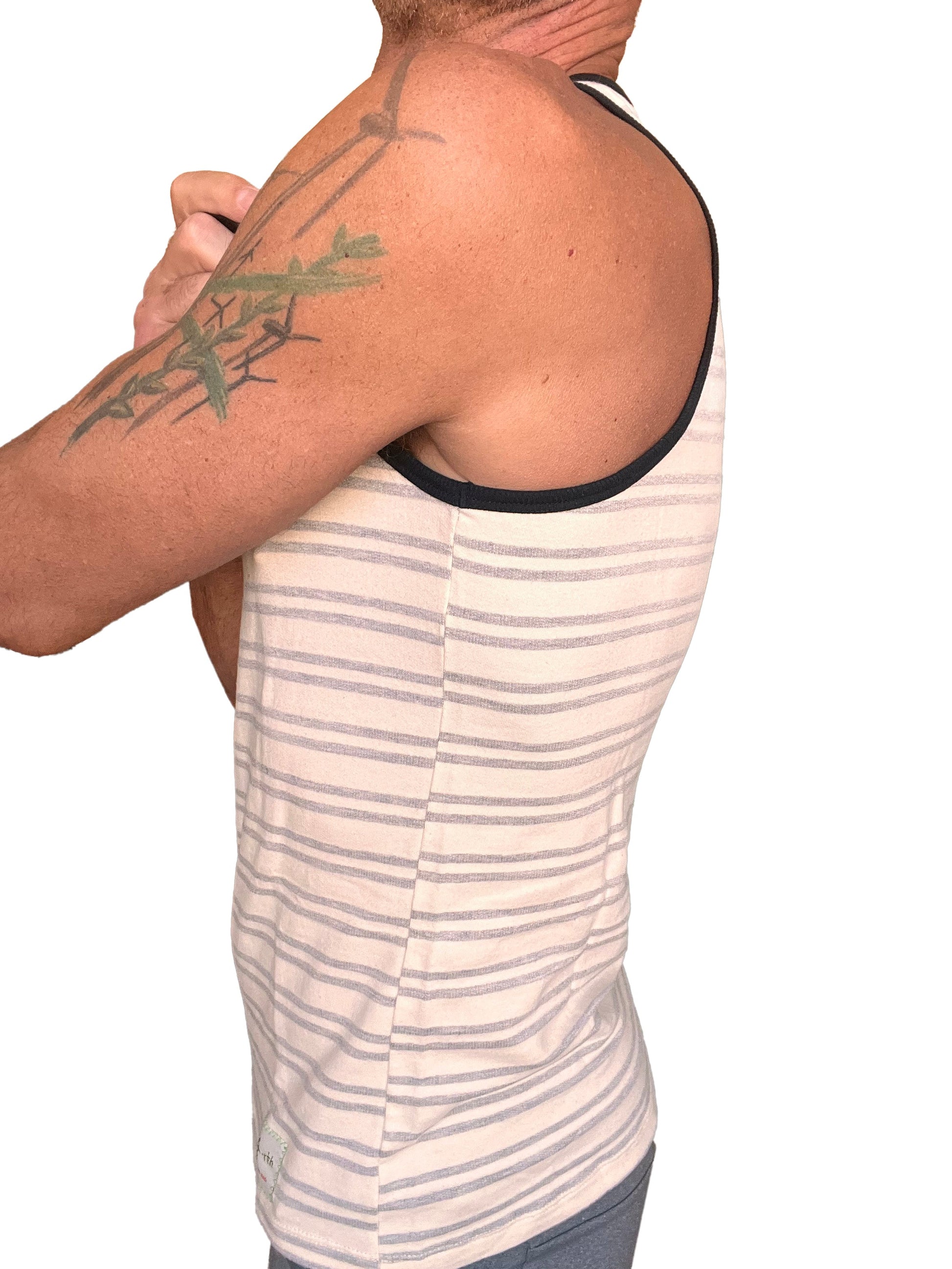 A man wearing a yummy nautical fleece sustain tank top in light gray stripe with black trim and beige accents