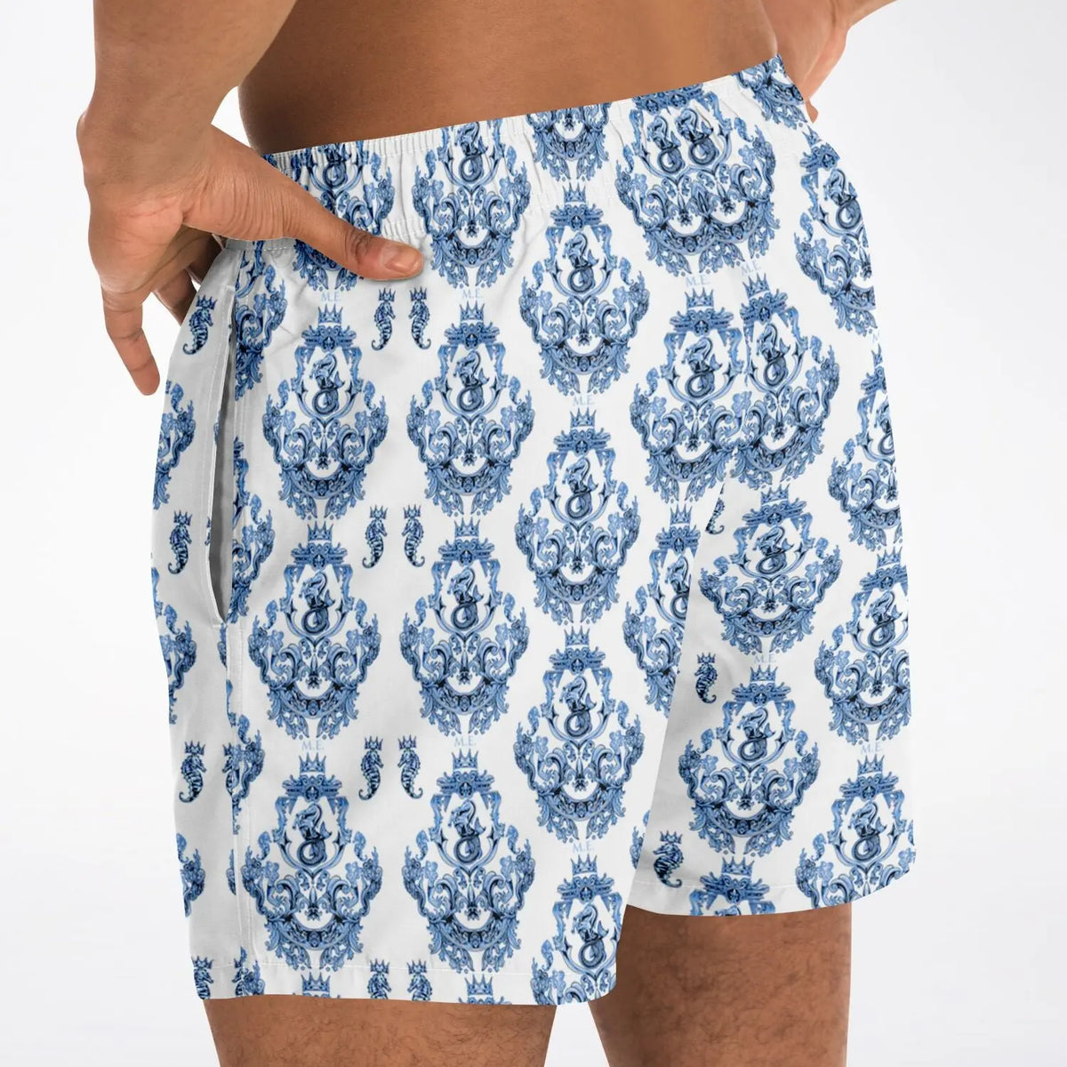 Men's swim shorts in blue baroque pattern made of lightweight fabric shown on a model with hands on hips by Maris Equi