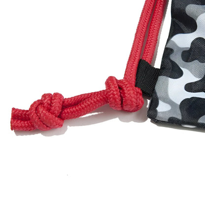 Red braided drawstring with knotted end on black and gray camouflage fabric of addicted camo backpack bag charcoal adf90