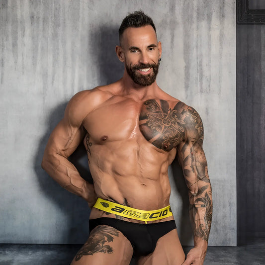 Black briefs with a bright yellow waistband featuring agacio branding in black lettering for active wear