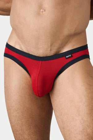 Red Aura briefs with dark trim and a small AWRY label, worn against a neutral background.
