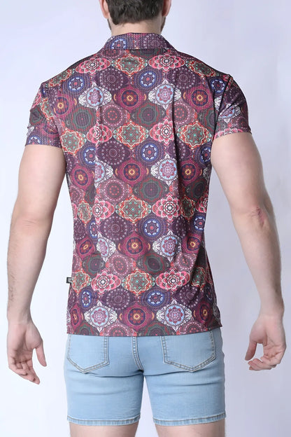 A man wearing a balboa button down shirt with a colorful purple pink and green mandala pattern on dark maroon fabric