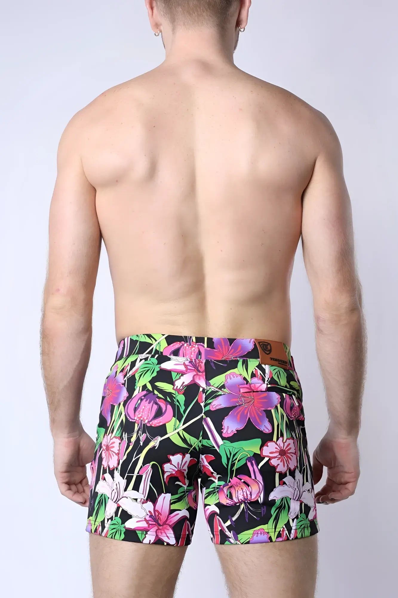 Balboa hybrid swim short featuring vibrant floral-patterned swim trunks in bold pink purple and green on black background