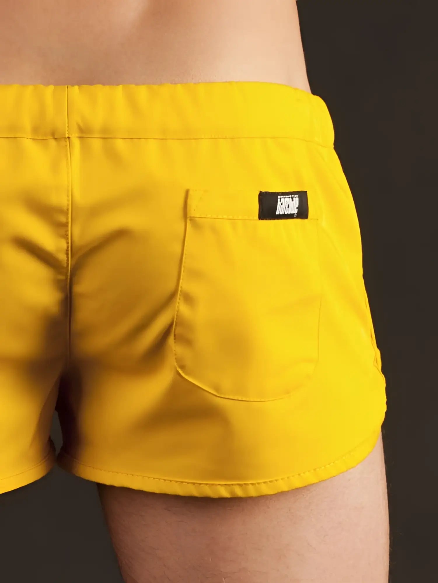 Bright yellow Barcode Berlin gym shorts with black brand patch on back pocket shown from the back side in size XL