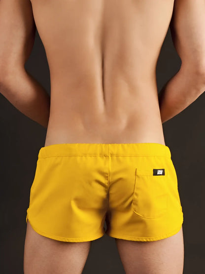 Back view of bright yellow Barcode Berlin gym shorts xl featuring sleek design and black brand tag on pocket