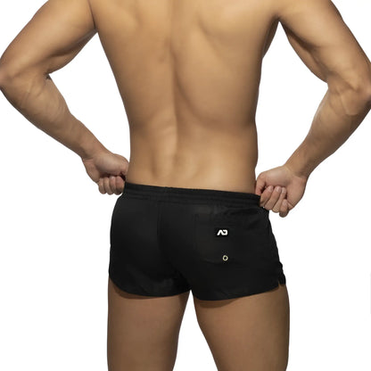 Back side of black basic mini short with white logo on the back pocket made of athletic material for active use