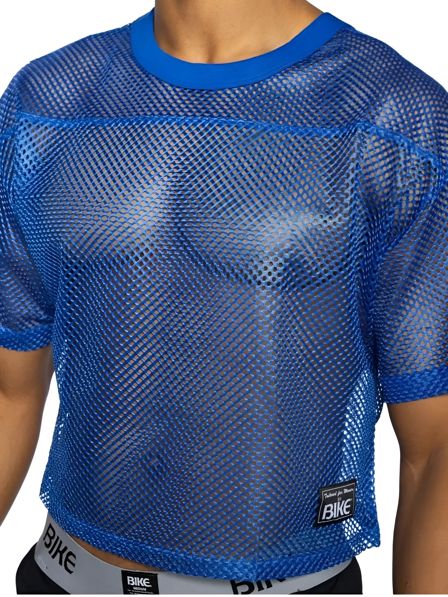 Blue mesh crop top with solid blue ribbed neckline and cuffs featuring black bike brand patch in royal color