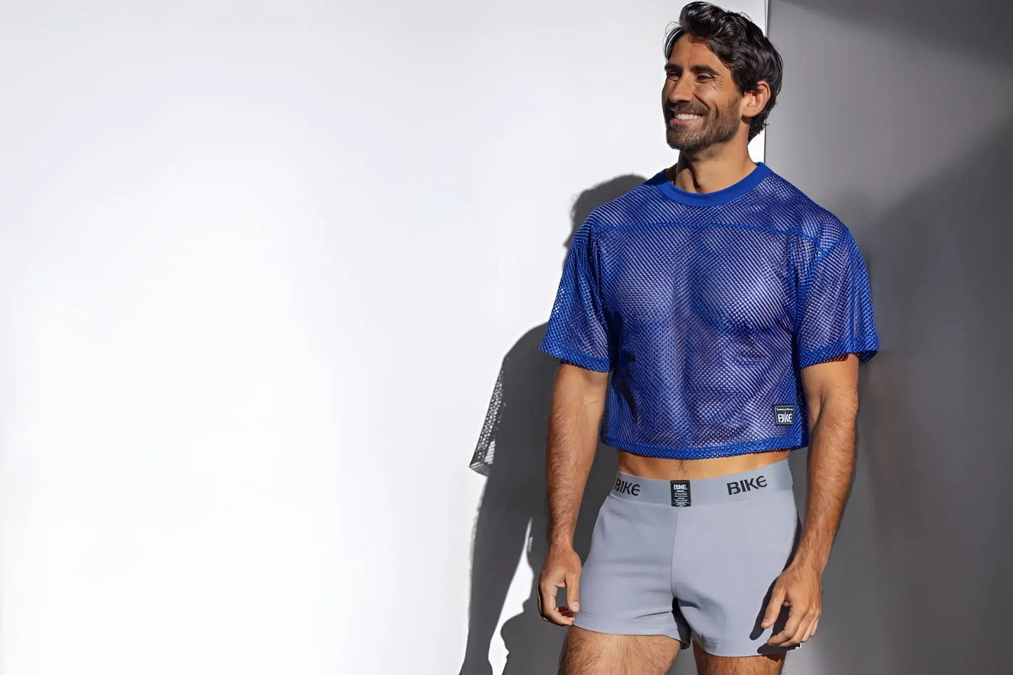 Blue mesh crop top with subtle textured pattern and small black logo on lower left side in royal color for biking practice