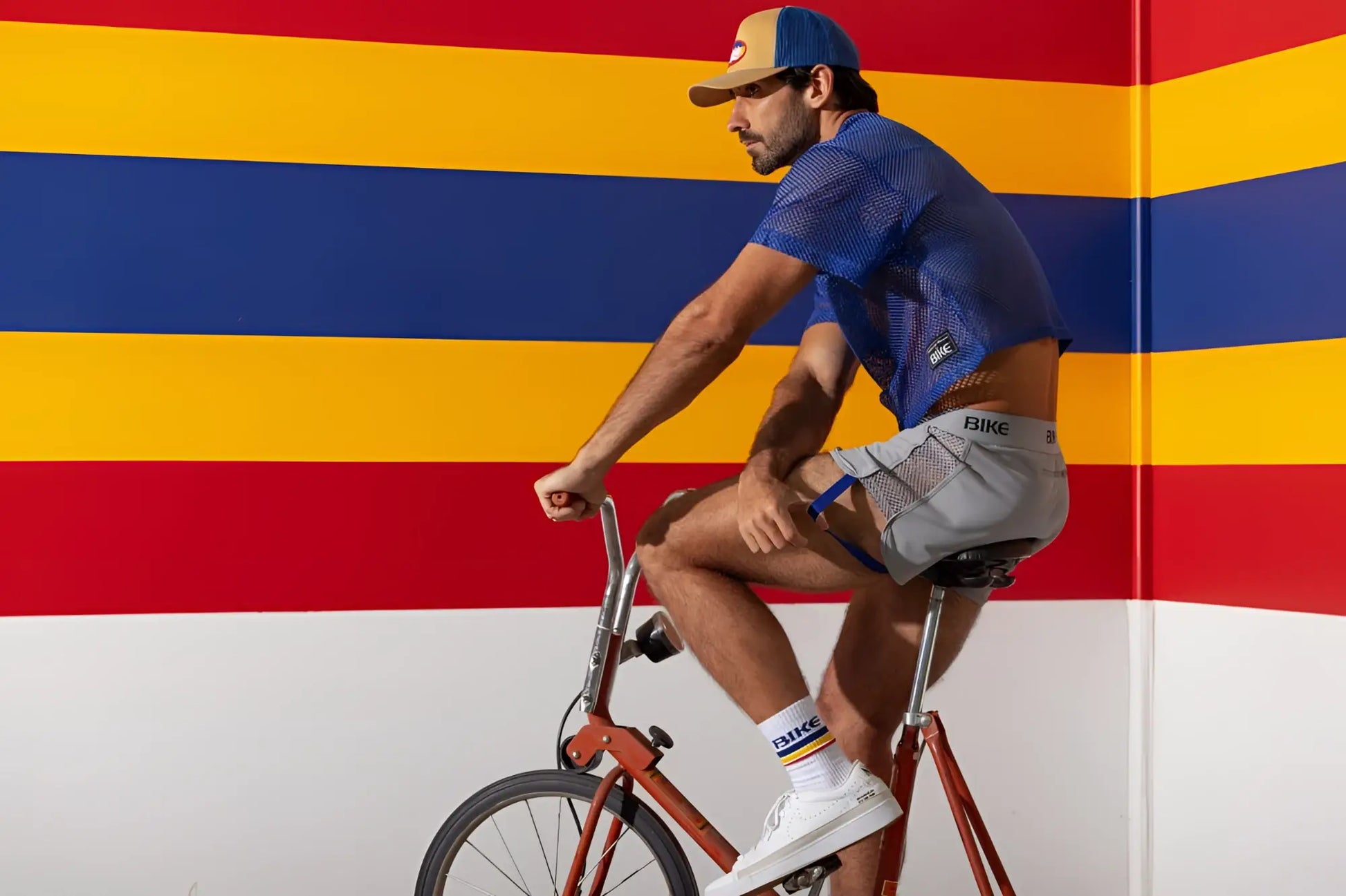 Man wearing bike athletic bam134 royal blue mesh short sleeve practice jersey and gray bike shorts with bike branding