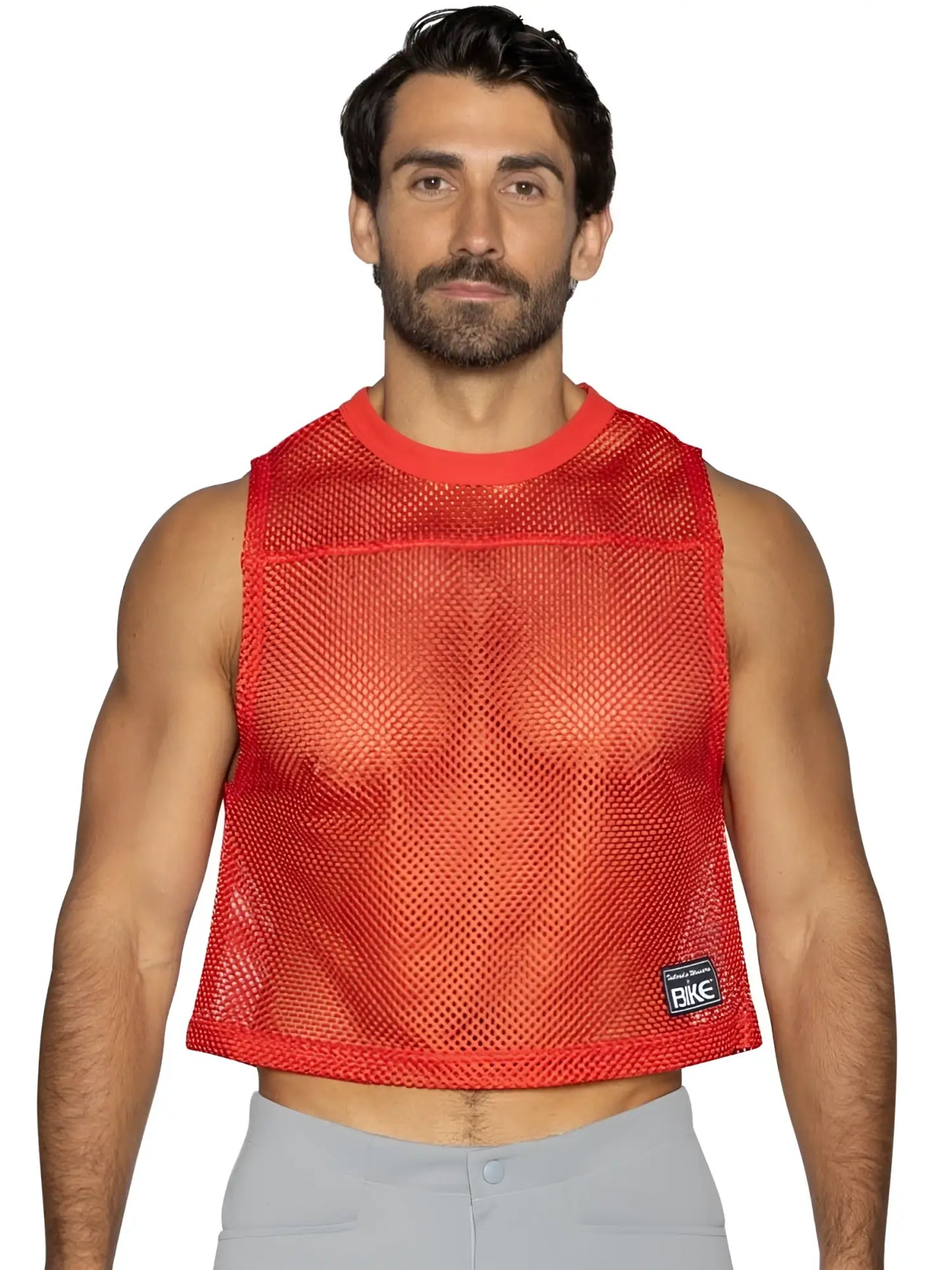 Red mesh crop top with ribbed neckline and hem featuring small black bike brand patch on lower right side for athletic use