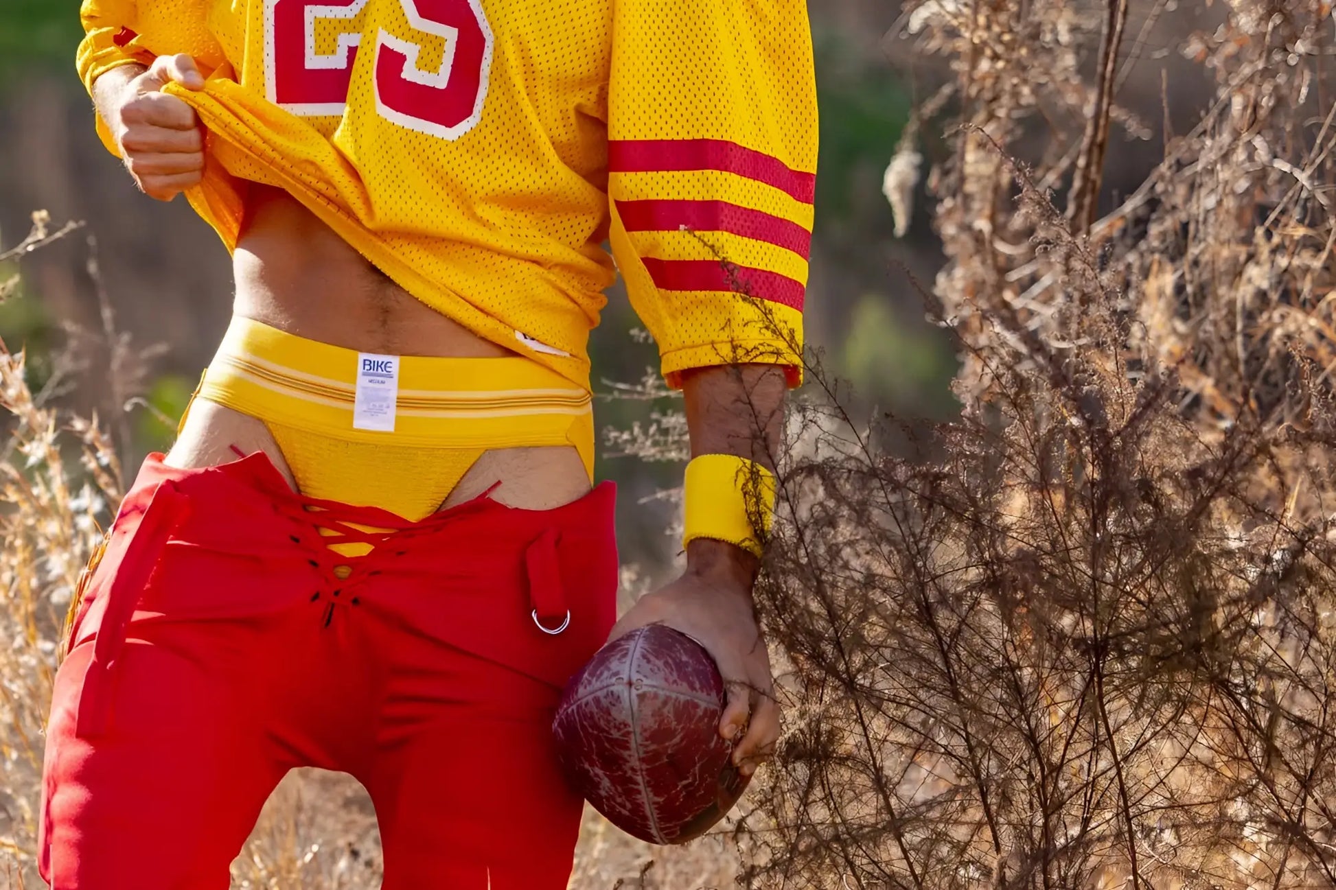 Yellow mesh football jersey with number 23 and a yellow Bike athletic jockstrap.