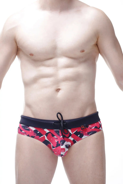 Bikini Ajoupa Chick red and black abstract patterned swim trunks with solid navy waistband for beachwear