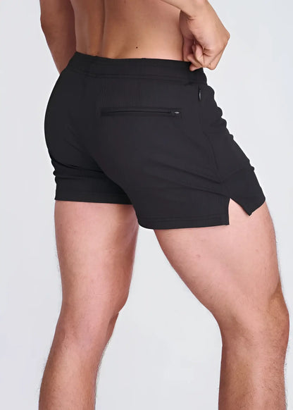 Back view of black seersucker swim shorts with mesh lining featuring a zippered back pocket and side slit