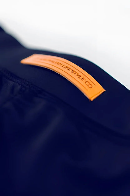 A tan leather lifestyle co patch embossed in black sewn on dark navy fabric of bondi short back side