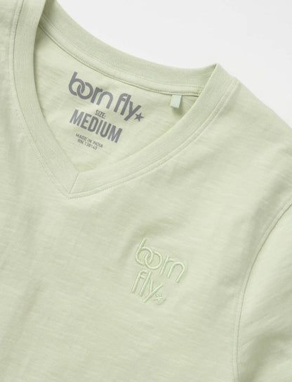 A light green cotton born fly v-neck tee with subtle embroidered logo on the chest and matching inside collar tag