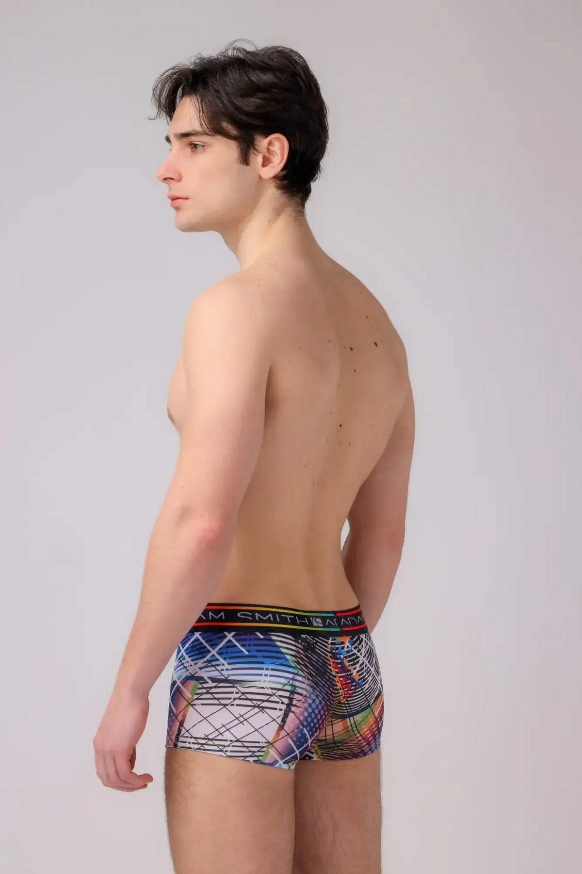 Multicolored abstract patterned menâs boyshort briefs with black elastic waistband featuring the m logo