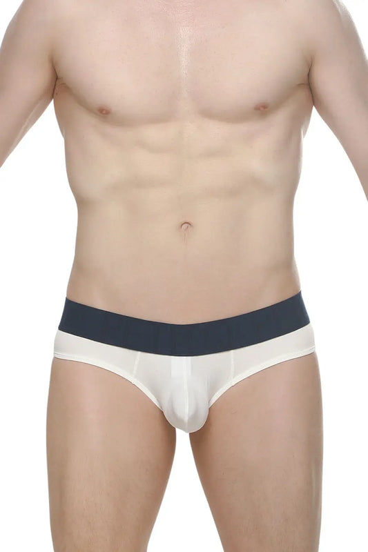 White men's brief with a navy waistband featuring a ribbed design shown on a model with a bare torso by PetitQ