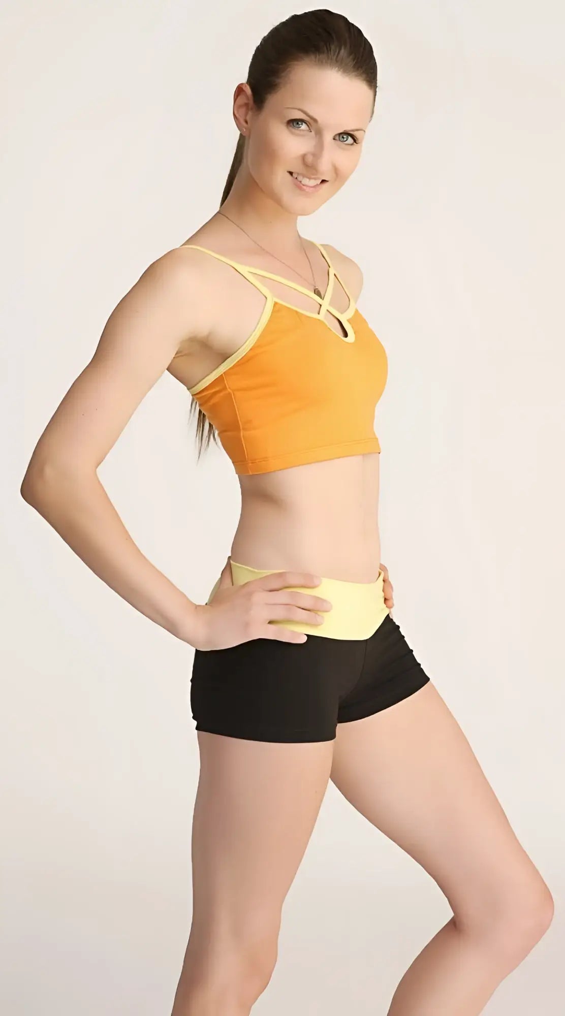 Orange and yellow bumble short sports bra with crisscross straps designed for activewear and support