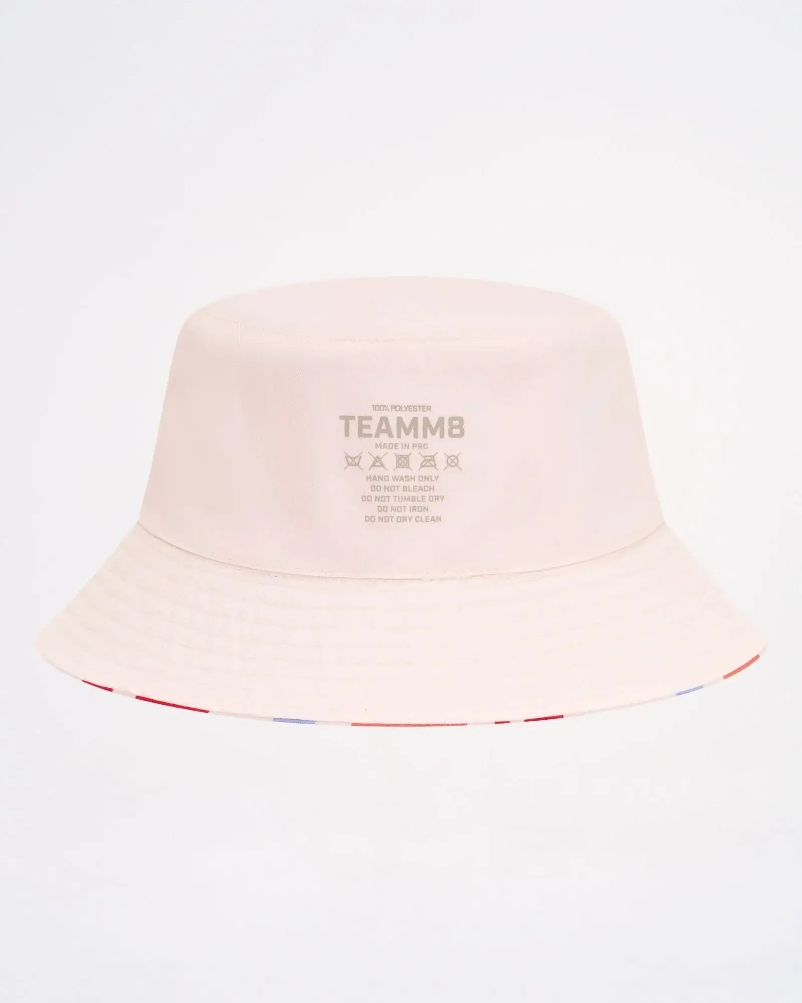 A soft blush pink cabana bucket hat featuring a subtle striped trim along the brim
